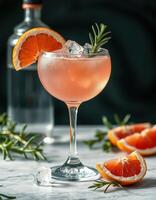Refreshing cocktail garnished with orange and rosemary in an elegant glass photo
