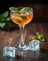 Refreshing cocktail served in an elegant glass with mint leaves and ice cubes on a wooden table photo