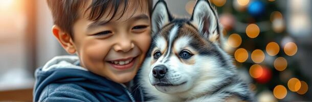Child joyfully embraces a husky puppy, capturing a heartfelt moment near a decorated Christmas tree photo
