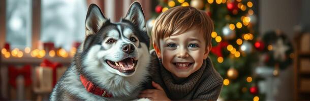Cheerful boy with a dog enjoying the holiday spirit in a decorated room with a Christmas tree photo