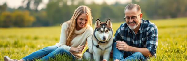 Couple enjoys quality time with their dog in a sunny meadow during late afternoon photo