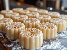 Intricate maamoul molds are filled fresh dough and imprinted decorative patterns resting on wooden countertop lightly coated flour photo