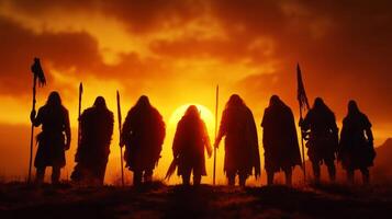 Participants gather on hilltop celebrate spring equinox holding staffs and ceremonial objects as dawn breaks. Their silhouettes are dramatically illuminated sun photo