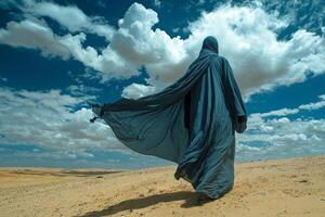 man dressed in traditional Islamic attire his jubba billowing in wind stands alone in expansive desert dynamic sky embodying peaceful moment of reflection and unity photo