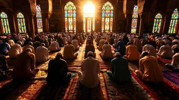 large group of Muslim worshippers stands in unison performing Salah inside grand mosque illuminated soft golden light from intricate stained glass windows photo