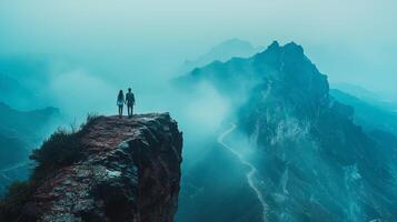 young couple stands hand in hand on edge of cliff surrounded majestic misty mountain peaks. Their journey represents moment of exploration and connection in nature photo