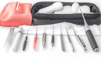 A collection of dental instruments neatly arranged on a white surface with a red pouch photo