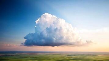 A large cloud is seen over a field photo
