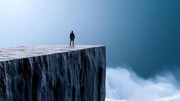 A man standing on a cliff looking out over the ocean photo