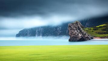 A green field with a rock in the middle of it photo