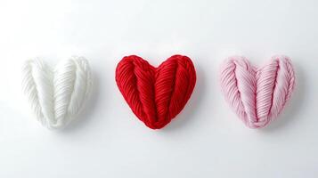 Three heart shaped yarns on a white surface photo