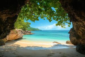 Serene tropical beach view through rock archway photo