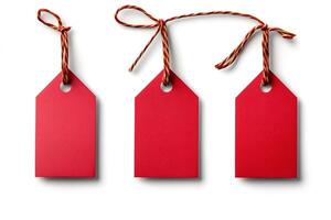 Three red blank hanging gift tags with gold and red string on white background photo