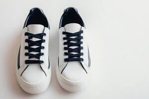 Pair of white sneakers with black laces on white background photo