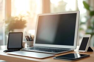 Laptop, tablet and smartphone are sitting on a desk in a luminous home office photo