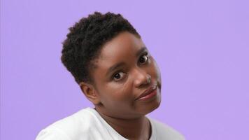 A young African American woman with plump features is isolated in a studio setting. She looks directly at the viewer with a thoughtful expression, showcasing her unique style and confidence. video