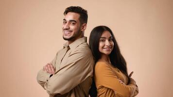 A young married Arab couple stands back to back in a studio against a light background. They exude joy and confidence, showcasing their connection and love in a simple yet elegant manner. video