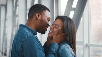 Two African American millennials are sharing a joyful moment at the airport, revealing excitement and connection. The indoor setting reflects their anticipation for traveling. video
