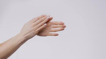 A young woman is seen applying skin care products to her hands in a minimalistic setting. This routine emphasizes self-care and hydration, highlighting the importance of pampering oneself. video