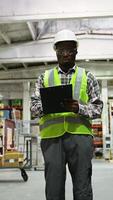 African American Warehouse Worker Inspecting Inventory with Clipboard video