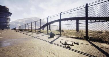 Abandoned location with a fence and ruined structures in a desert landscape video