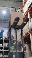 Warehouse employee using a forklift to transport a large box of goods through organized aisles, preparing the shipment for efficient delivery operations video