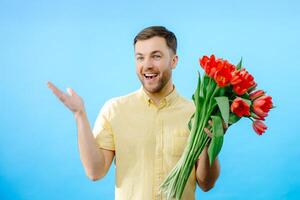 Man holding bunch of red flowers. photo