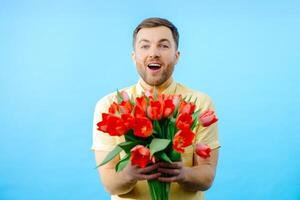 Man holding bunch of red flowers in hands photo