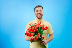 Man holding bouquet of red tulips in hands photo