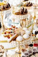 Delicious macarons and pastries decorating a luxurious candy bar buffet. photo