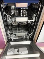 Modern stainless steel dishwasher with empty racks and detergent dispenser photo