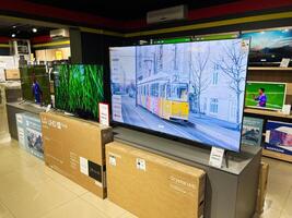 Kyiv, Ukraine - February 04, 2025 Modern television display in an electronics store with various large screen models showcased photo