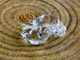 Glass figurine in the form of kissing piglets on a wooden background photo