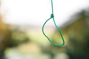 Green rope hanging loop. Concept, tying rope knots in daily life. String for fasten things or objects. photo