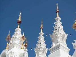 White and gold pagoda on a clear sky background in a Thai temple. photo