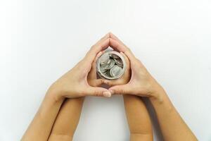 Two hands holding a small coin in the shape of a heart photo