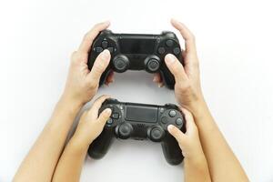 Two hands holding two game controllers on a white background photo
