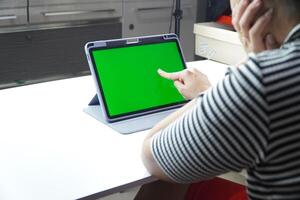 A person is using a tablet with a green screen photo