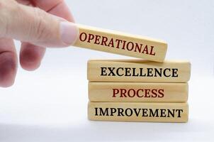 Operational Excellence and Process Improvement text on wooden blocks with small ladder background. Business concept photo
