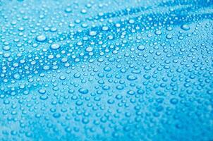 Side view of droplets with blue color background suitable for wallpaper photo