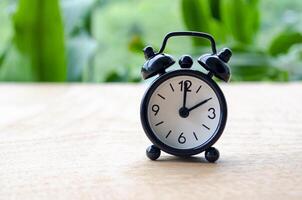 Table alarm clock pointing at 2 pm or 2 am with customizable space for text. Time management concept and copy space photo
