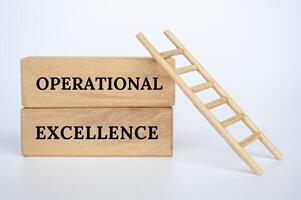 Operational Excellence text on wooden blocks with small ladder background. Business concept photo