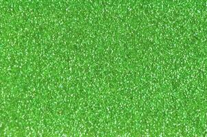 Close up of a green glitter or sparkle texture and can be used as a background or wallpaper for designs. photo