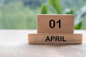 1 April calendar on wooden table with customizable space for text, ideas or messages. Calendar and copy space concept photo