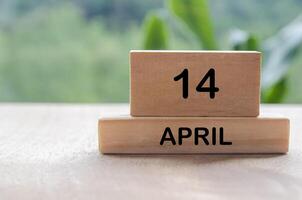14 April calendar on wooden table with customizable space for text, ideas or messages. Calendar and copy space concept photo