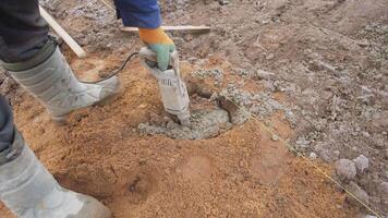 A dedicated worker mixes concrete at a busy construction site, prioritizing safety and the proper blend video