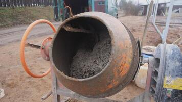 The image shows a closeup of a concrete mixer, vital for various construction and building projects video