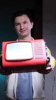 Man showing old portable television with blank screen video