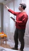vertical handyman man using tablet while inspecting home renovation project apartment DIY video