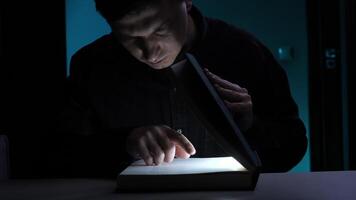 Man reading book with built-in light in dark room. light from the book video